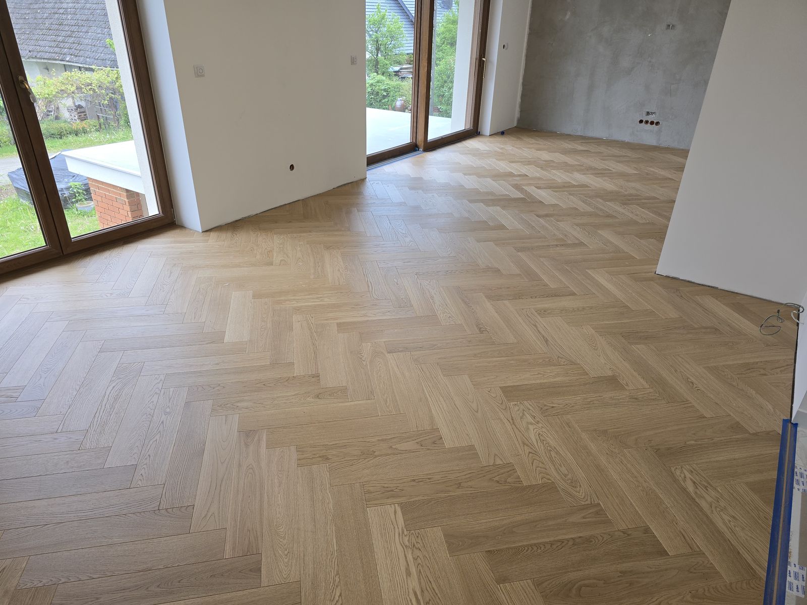 Jasna dębowa jodełka w domu jednorodzinnym z dużymi oknami – realizacja Perfekt Parkiet