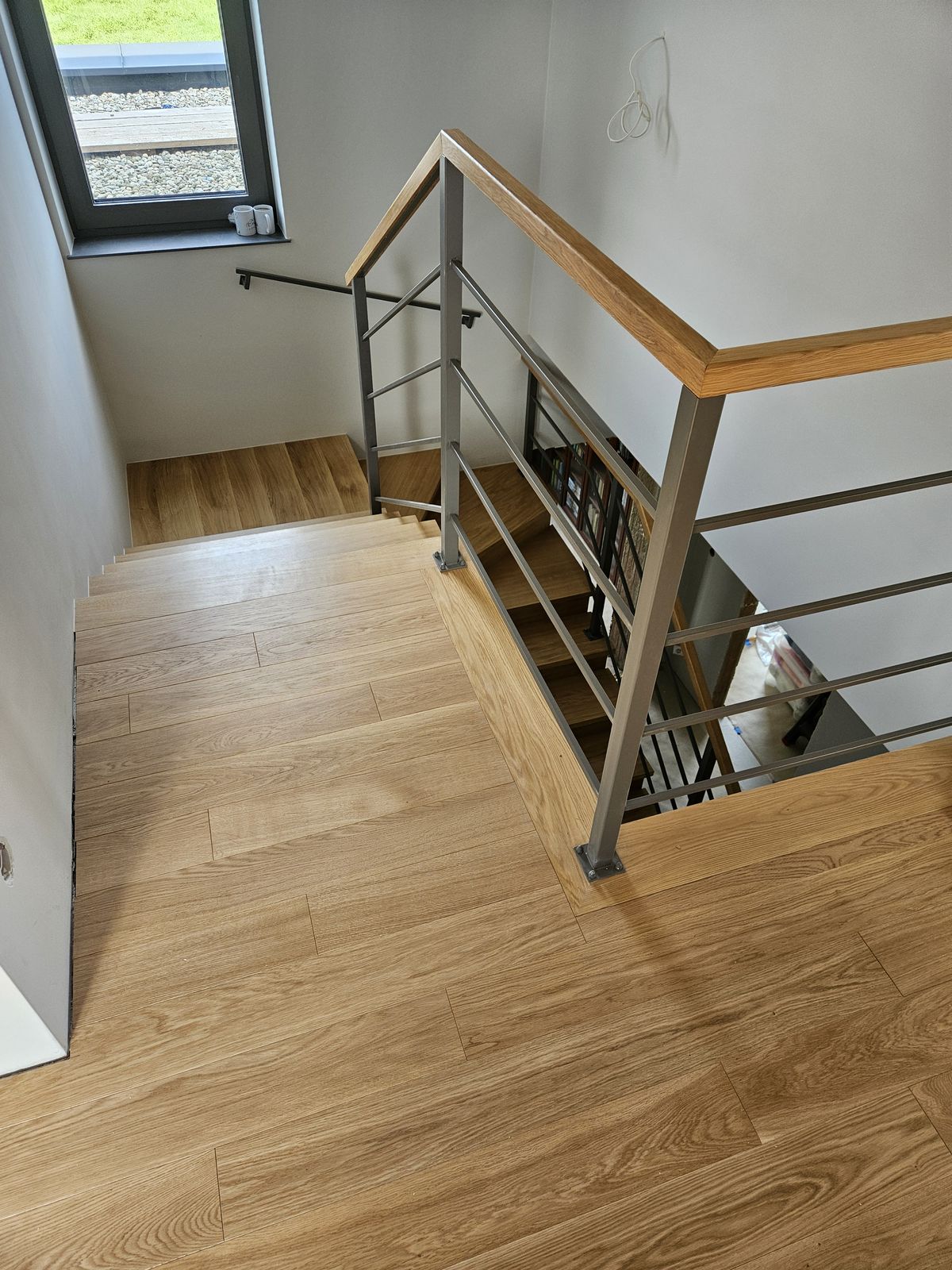 Dębowe deski na podeście przy schodach z balustradą – realizacja Perfekt Parkiet
