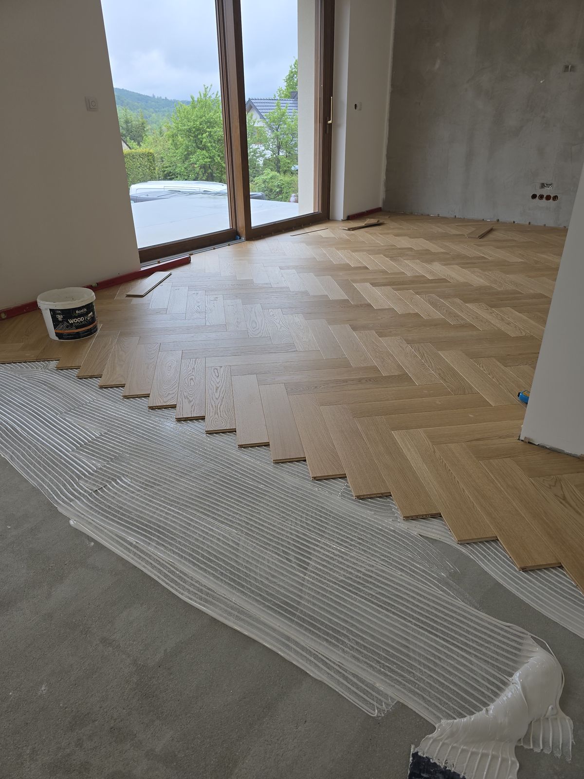 Układanie dębowej jodełki na kleju na przygotowanej wylewce – realizacja Perfekt Parkiet
